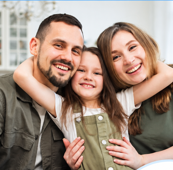 A family of three embracing and smiling.